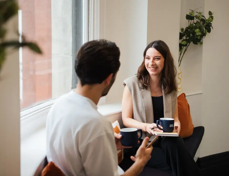 a man and woman sitting in a chair and talking