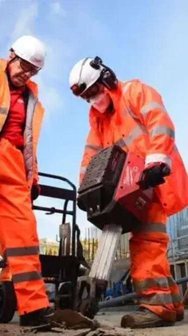 a group of men wearing orange overalls and white helmets