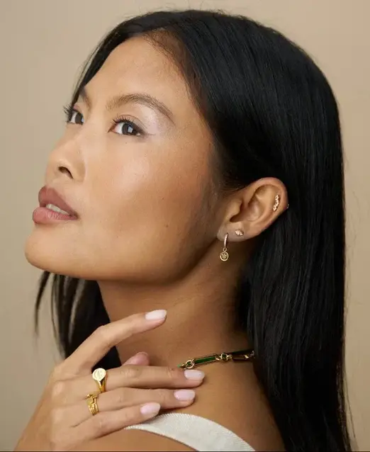Model wearing gold hoop earrings