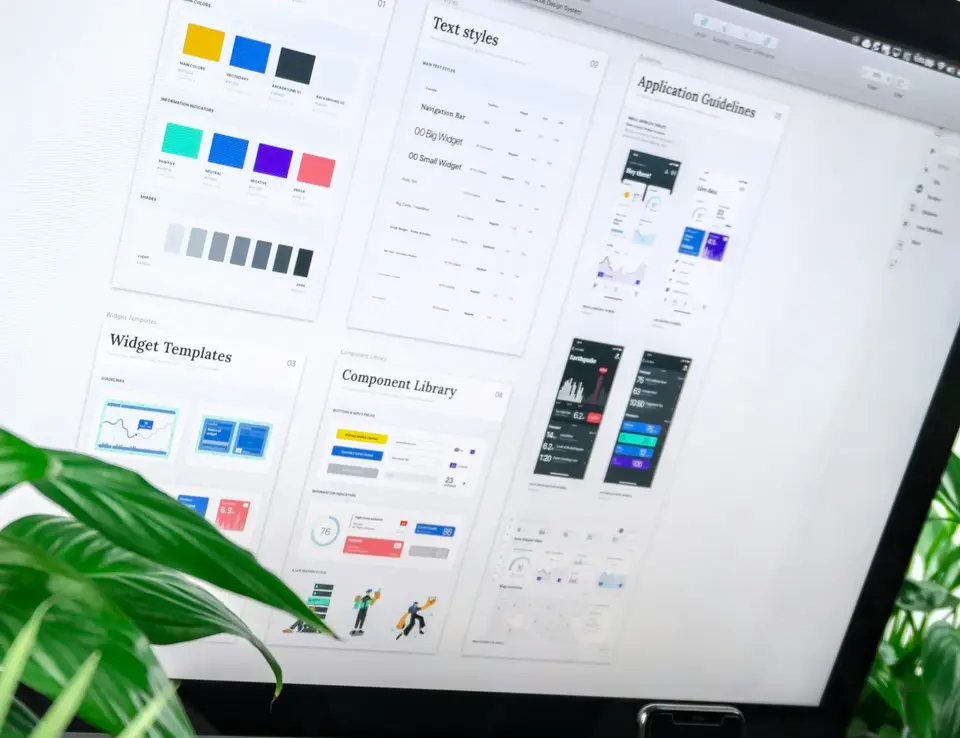 a computer on a desk with a plant