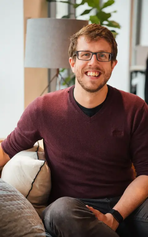 a man sitting on a couch smiling