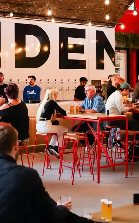 People sitting at high tables in Camden Brewery venue
