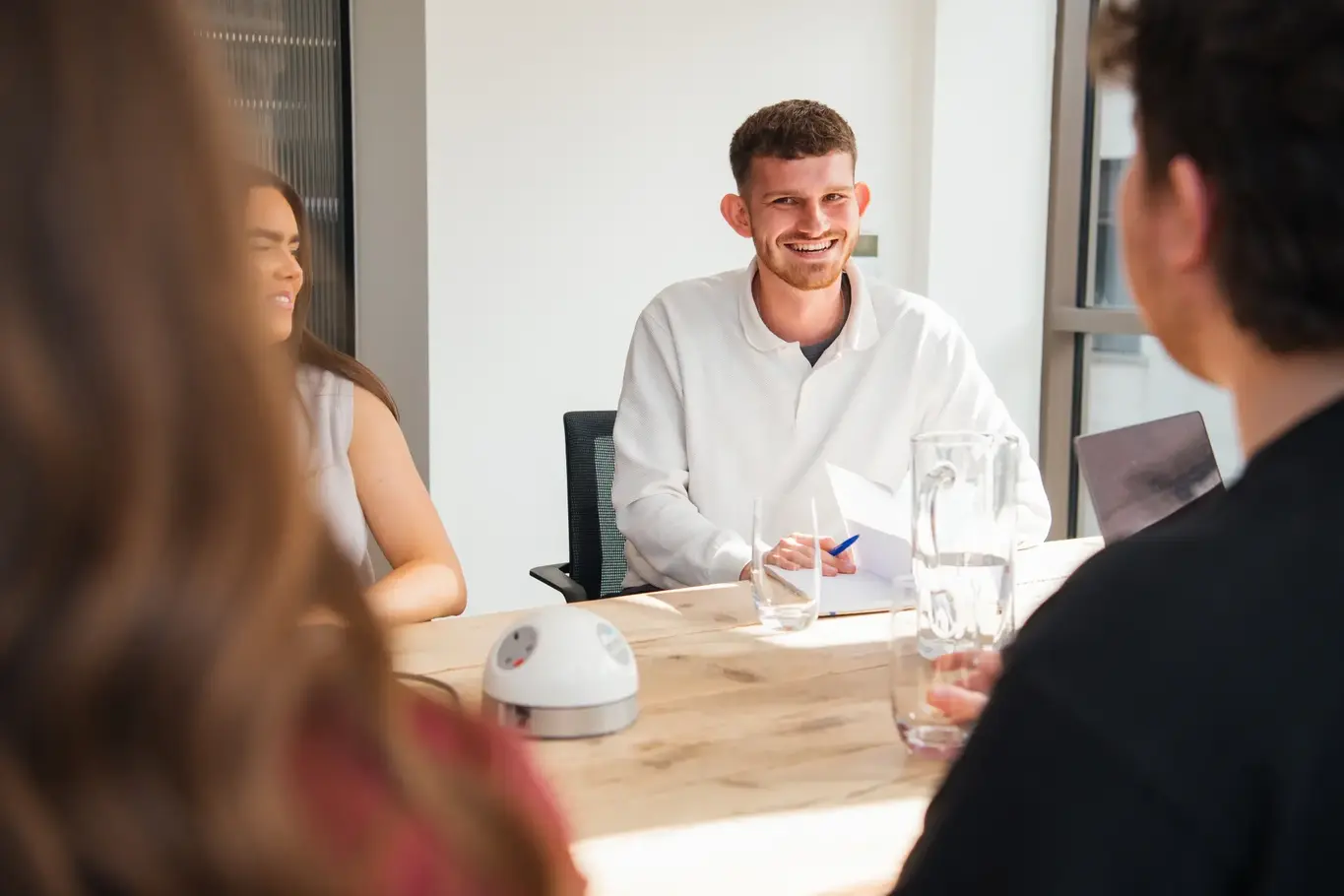 a man sitting at a table with people around him