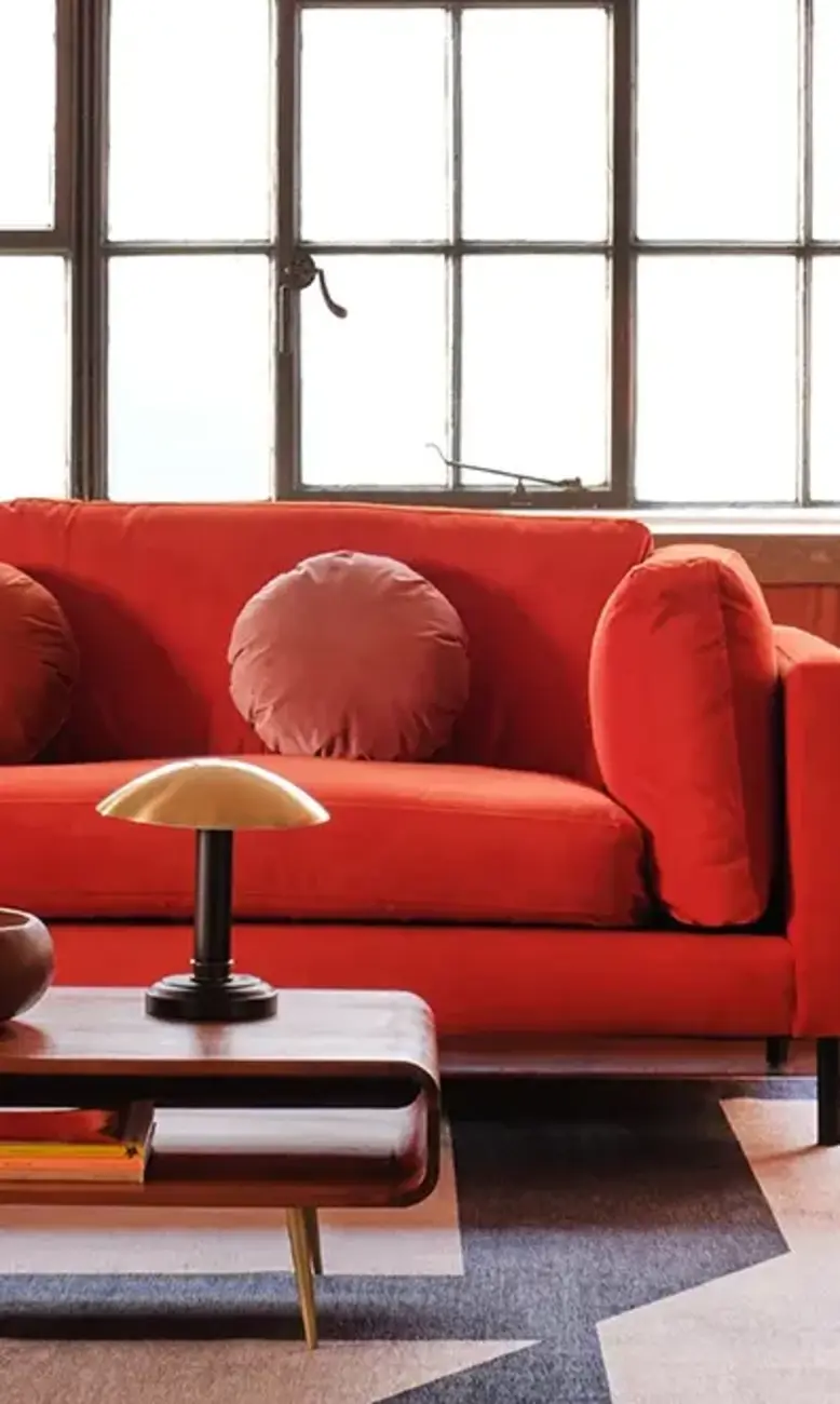 a living room with a couch and a lamp