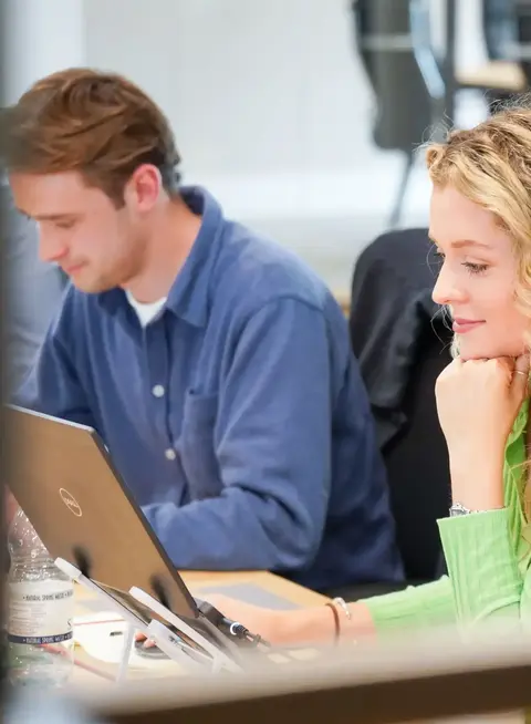a woman in green shirt looking at a laptop