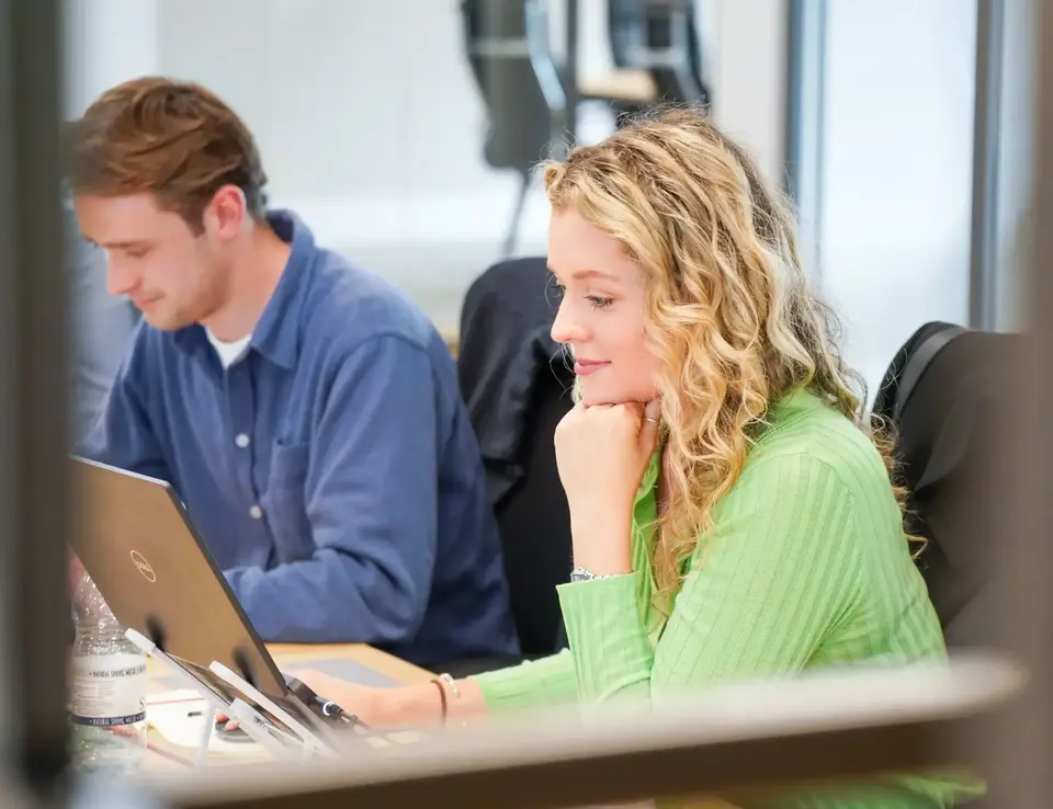 a woman in green shirt looking at a laptop