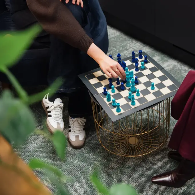 a person playing chess with a gold cage