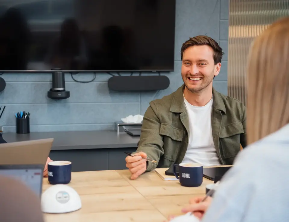 a man sitting at a table with a woman and a laptop