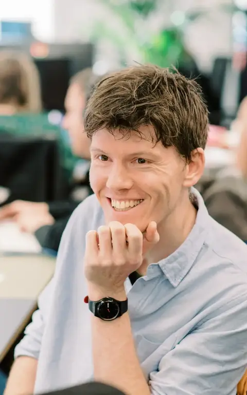 a man sitting at a desk with his hand on his chin