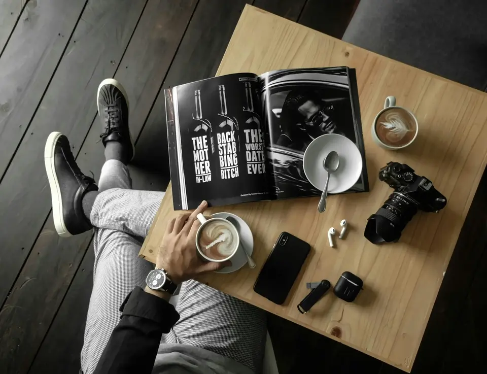 a person sitting on a table with a magazine and a book