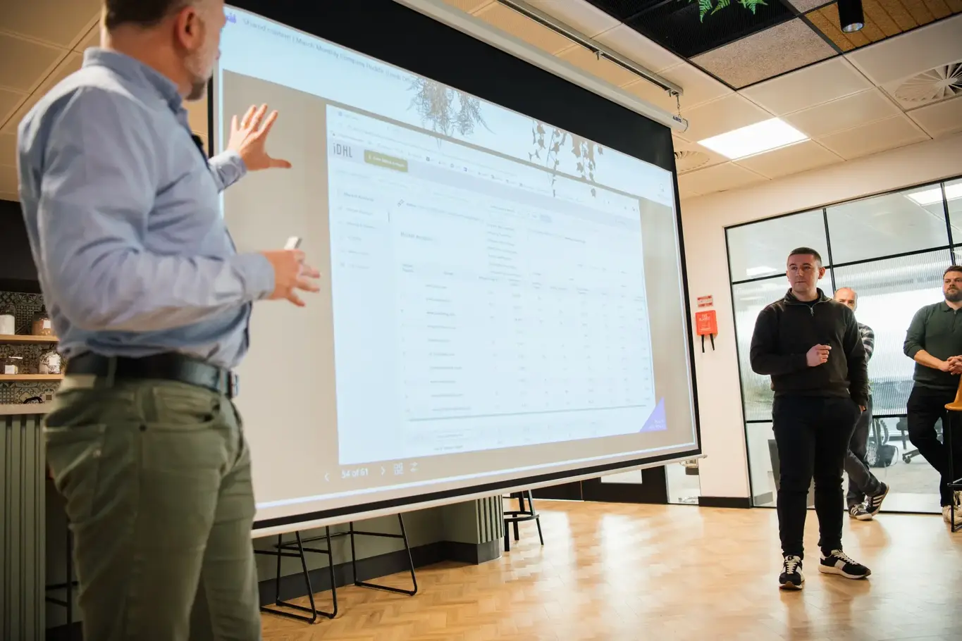a man standing in front of a large screen