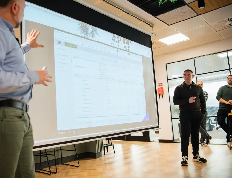 a man standing in front of a large screen