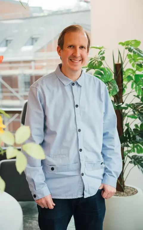 a man standing in front of a plant