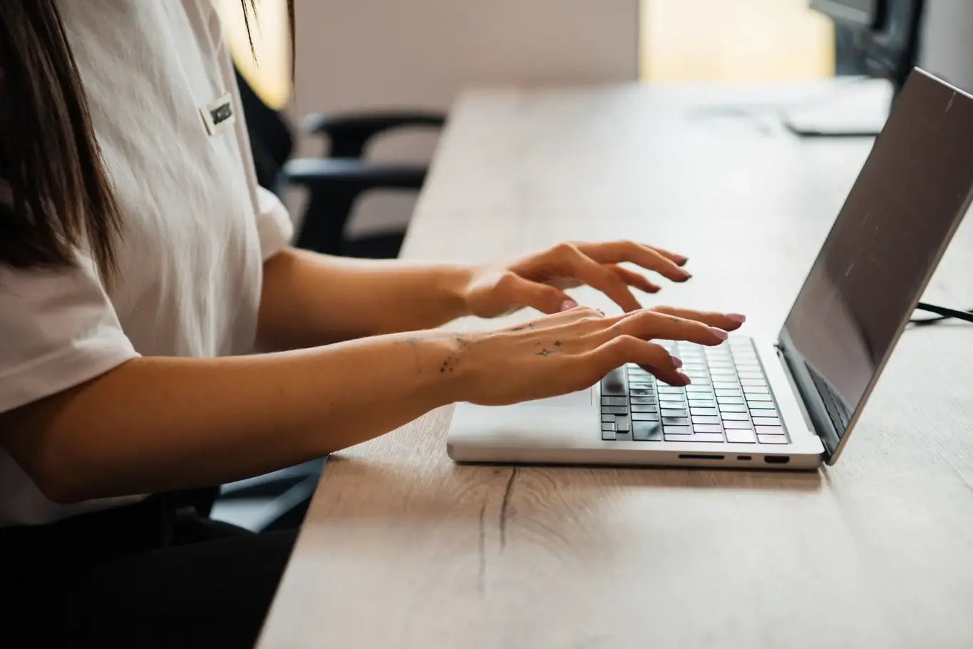 a woman typing on a laptop
