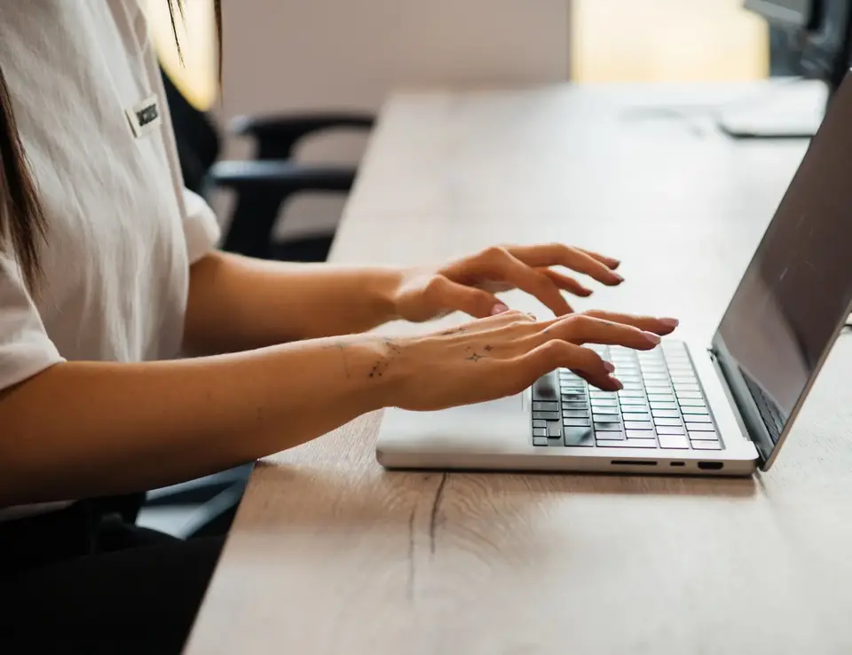 a woman typing on a laptop