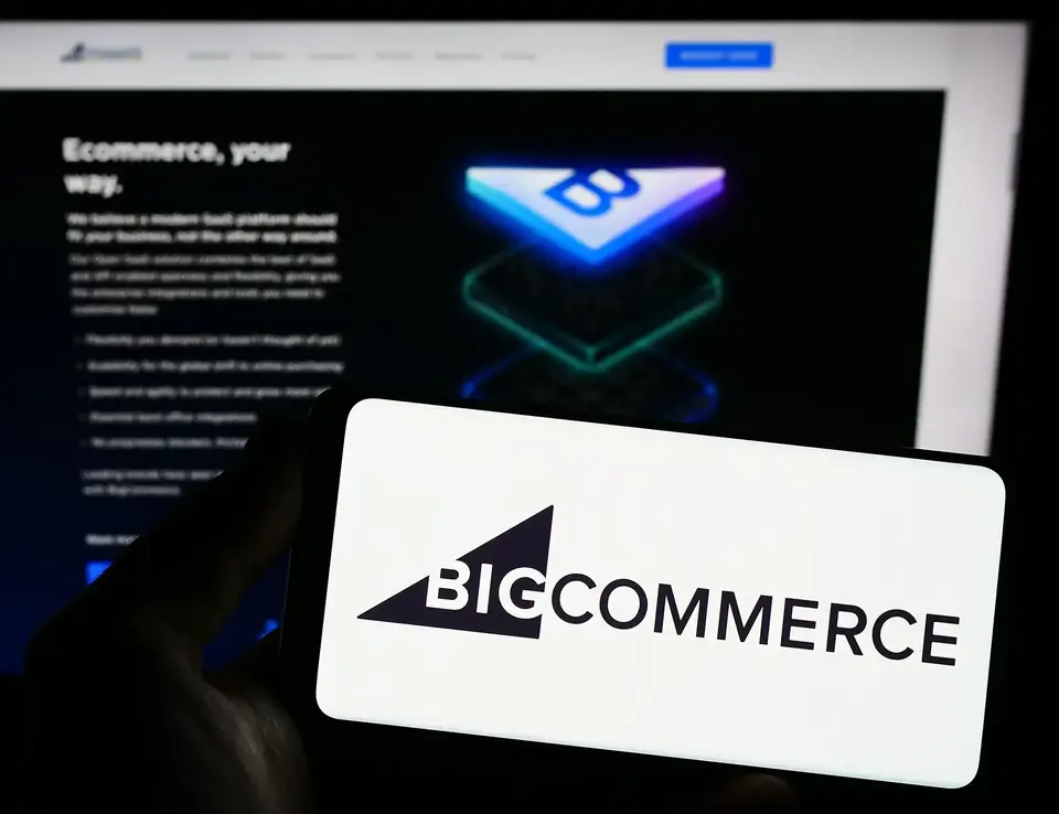 a hand holding a phone with a logo on it