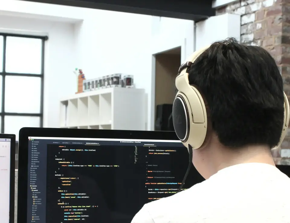 a man wearing headphones looking at a computer screen