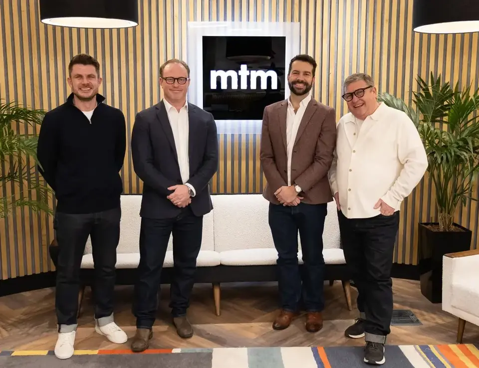 a group of men standing in front of a white couch