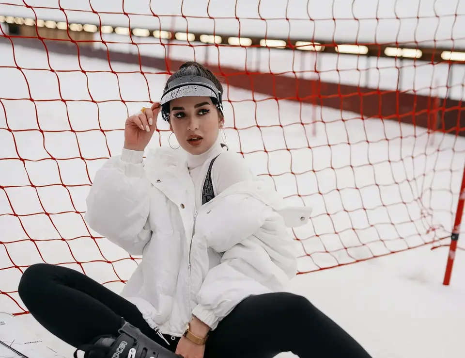 a woman sitting on snow with skis