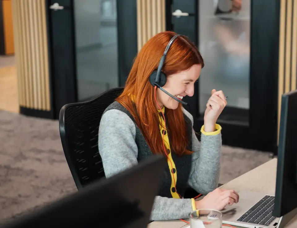 a woman wearing headphones and using a computer