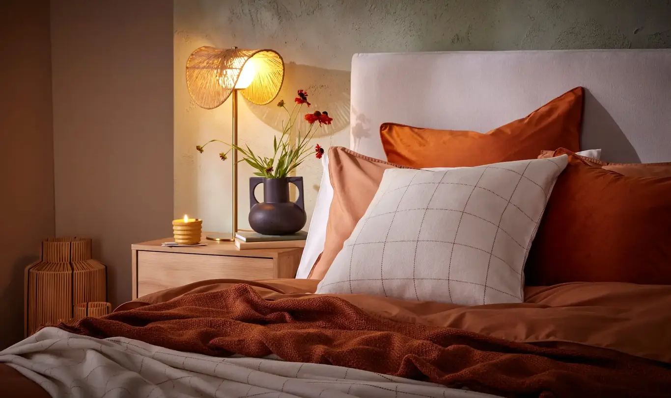 a bed with a lamp and flowers