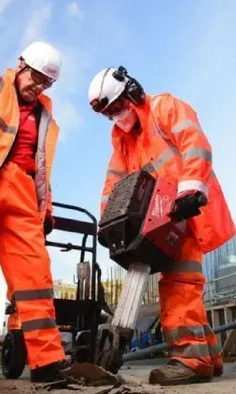 a group of men wearing orange overalls and white helmets