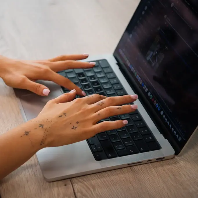 a person's hands on a laptop keyboard