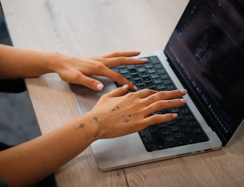 a person's hands on a laptop keyboard
