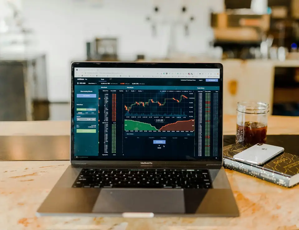 A laptop screen displaying stock market graphs
