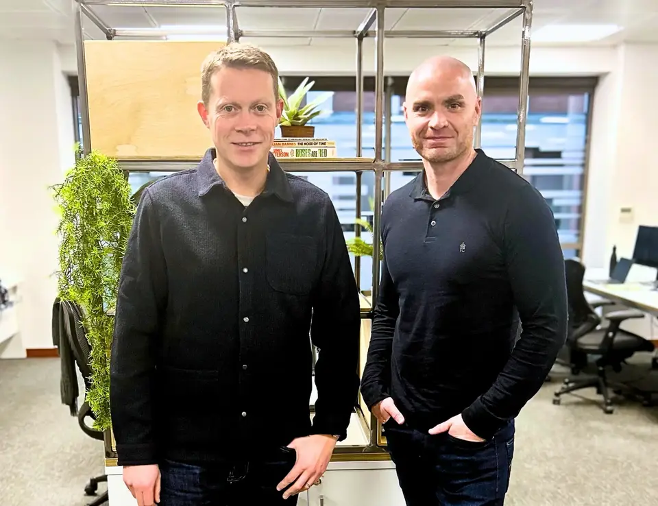 two men standing in front of a glass shelf