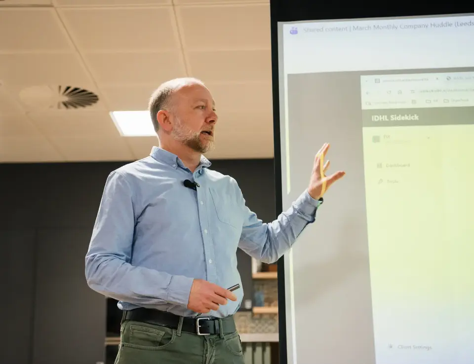 a man standing in front of a large screen