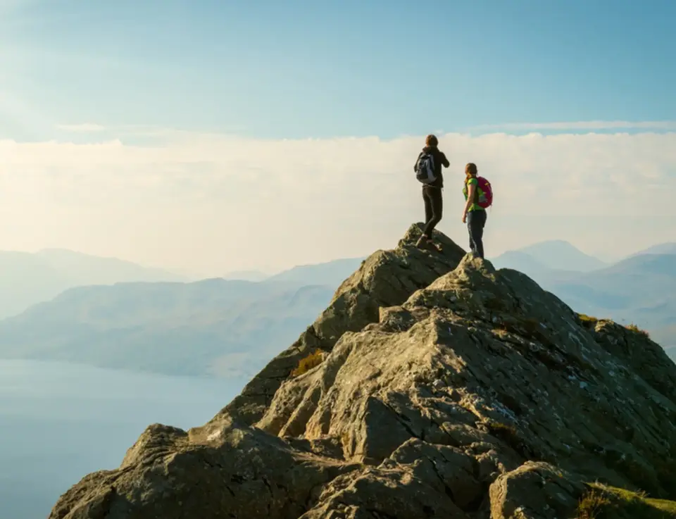 two people standing on a rock
