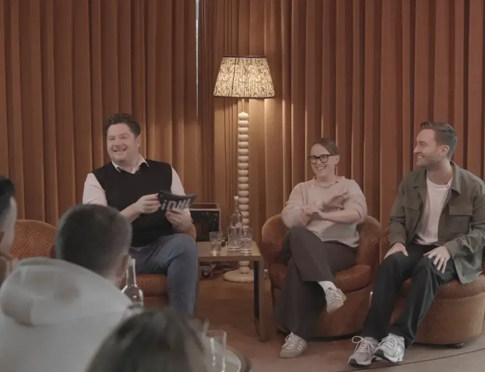 3 people sat in front of crowd, engaged in a fireside chat