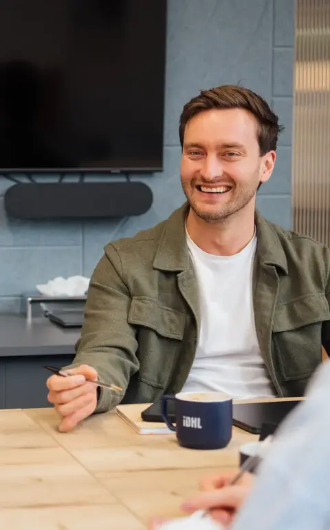 a man sitting at a table with a woman and a laptop
