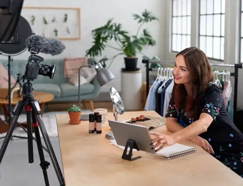 a woman sitting at a desk with a camera