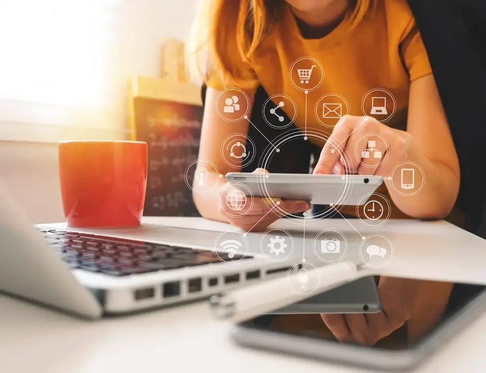 a woman using a tablet and a laptop