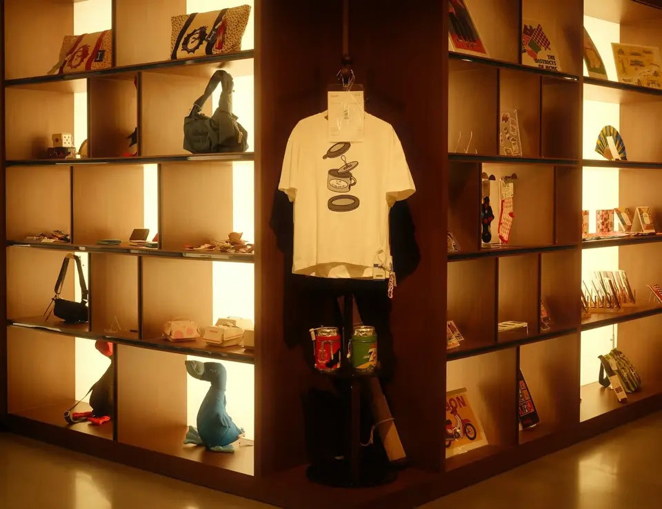 Low lit handbag and tshirt display in a clothing store