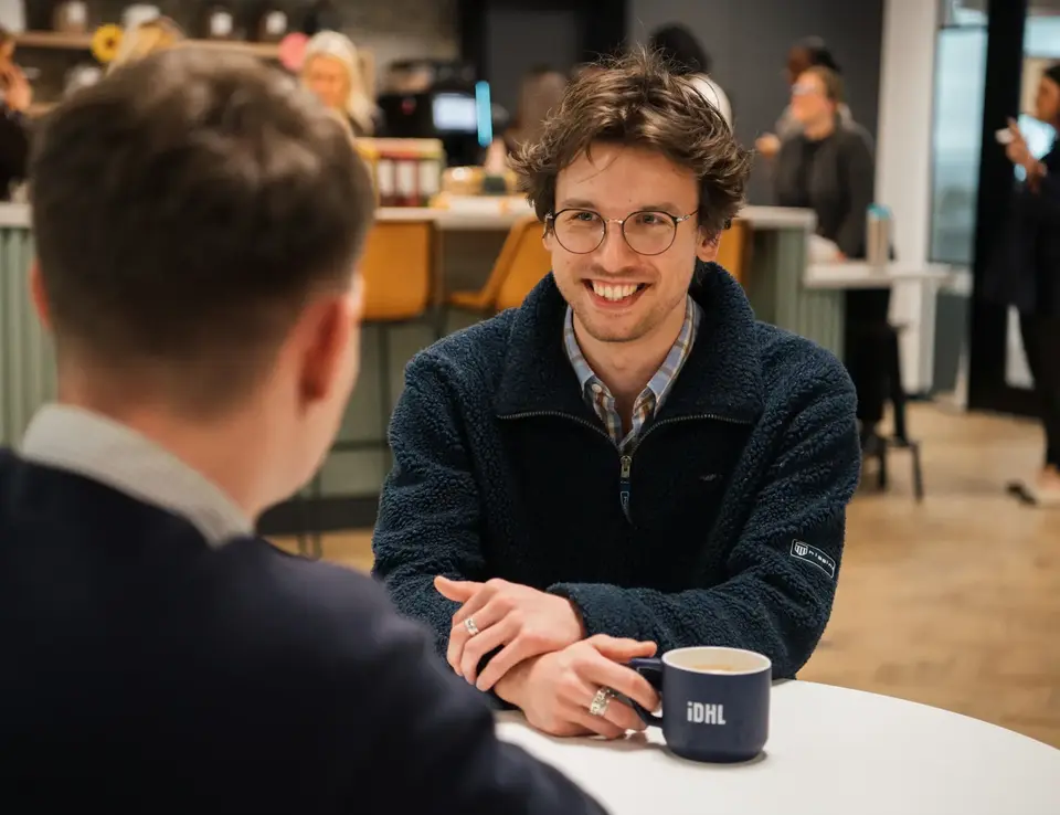 a man sitting at a table with a cup of coffee