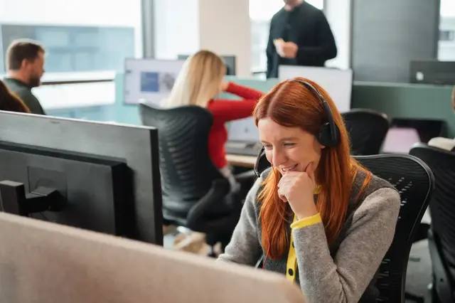 IDHL employee wearing a headset at a desktop