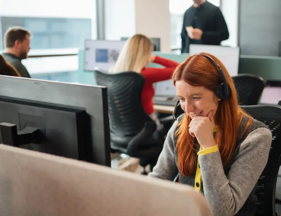 IDHL employee wearing a headset at a desktop