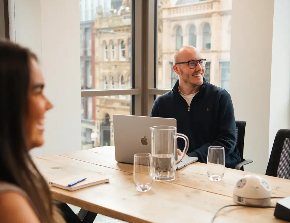a man sitting at a table with a laptop