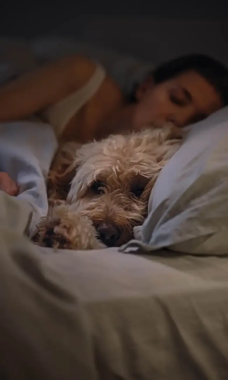 a woman sleeping with a dog