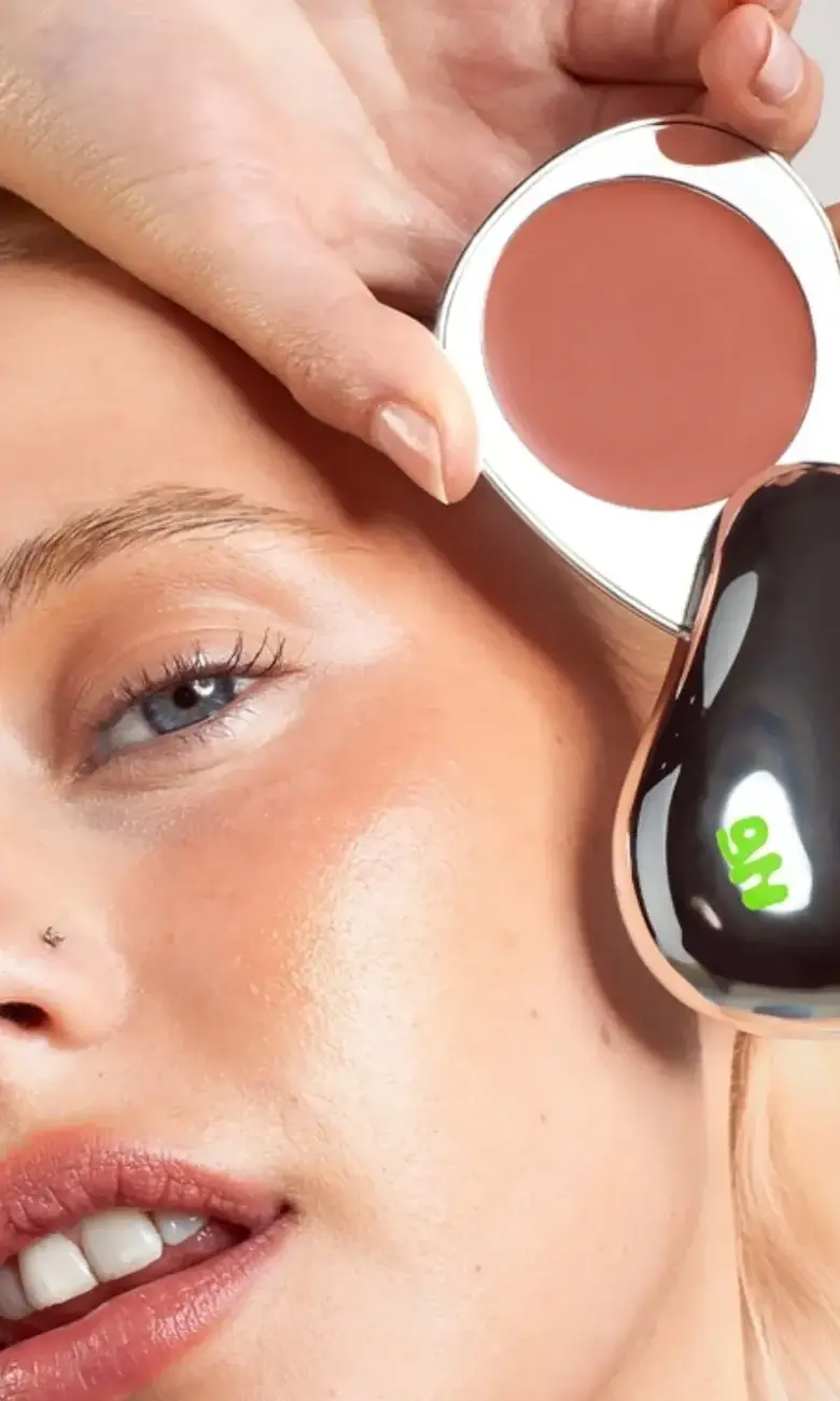 a woman holding a makeup brush