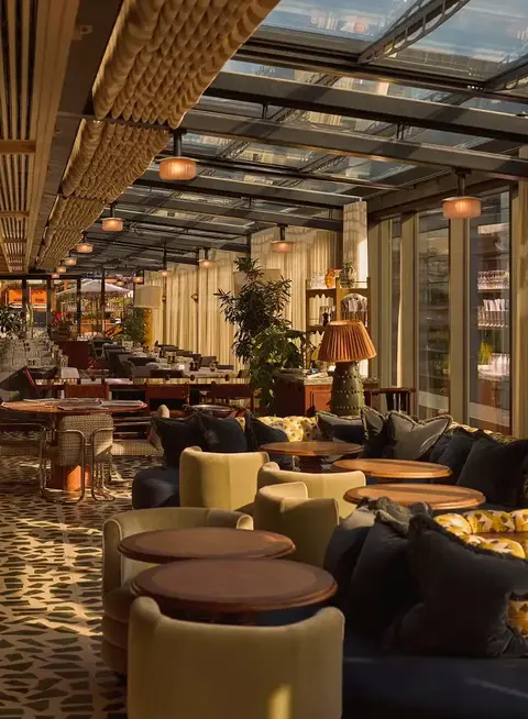 a room with a glass roof and tables and chairs