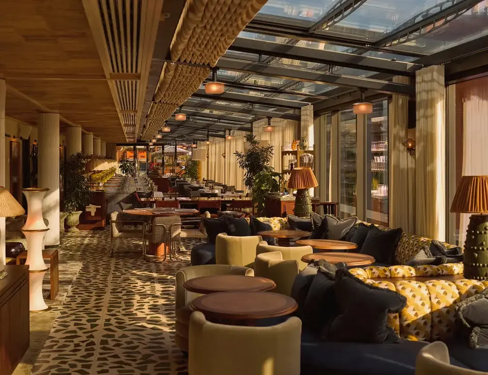 a room with a glass roof and tables and chairs