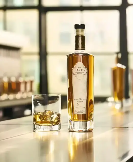 a bottle of alcohol next to a glass of ice