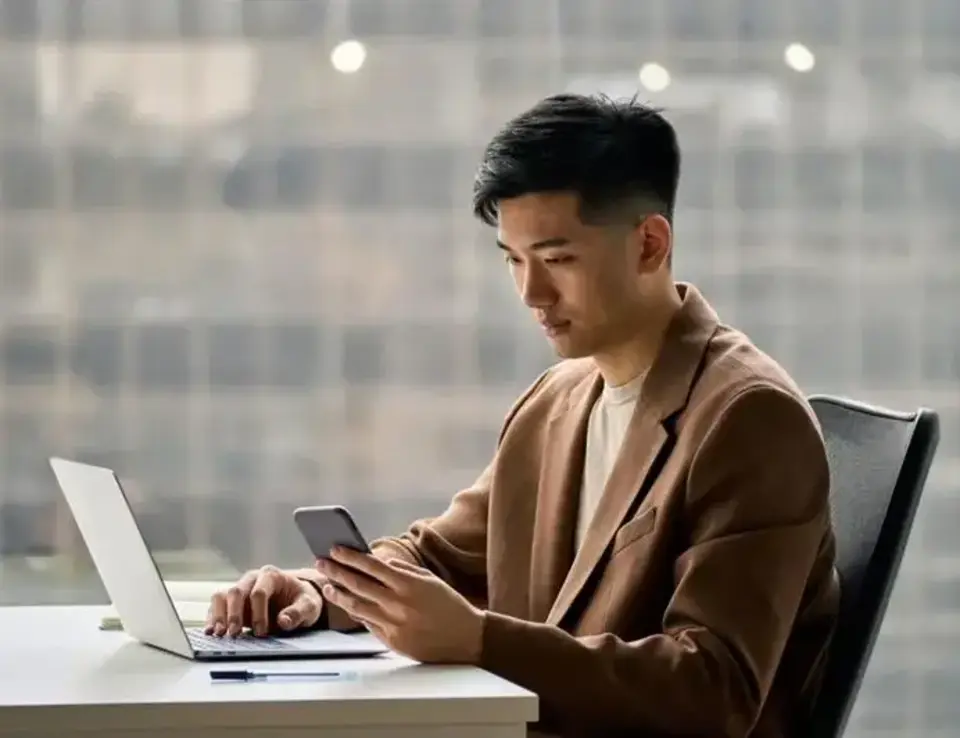 a man sitting at a desk using a laptop
