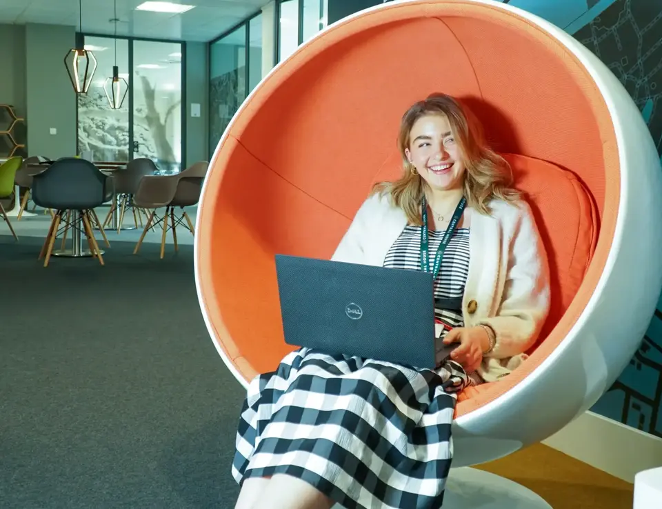 a woman sitting in a chair with a laptop