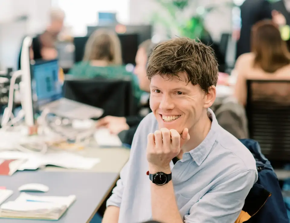 a man sitting at a desk with his hand on his chin