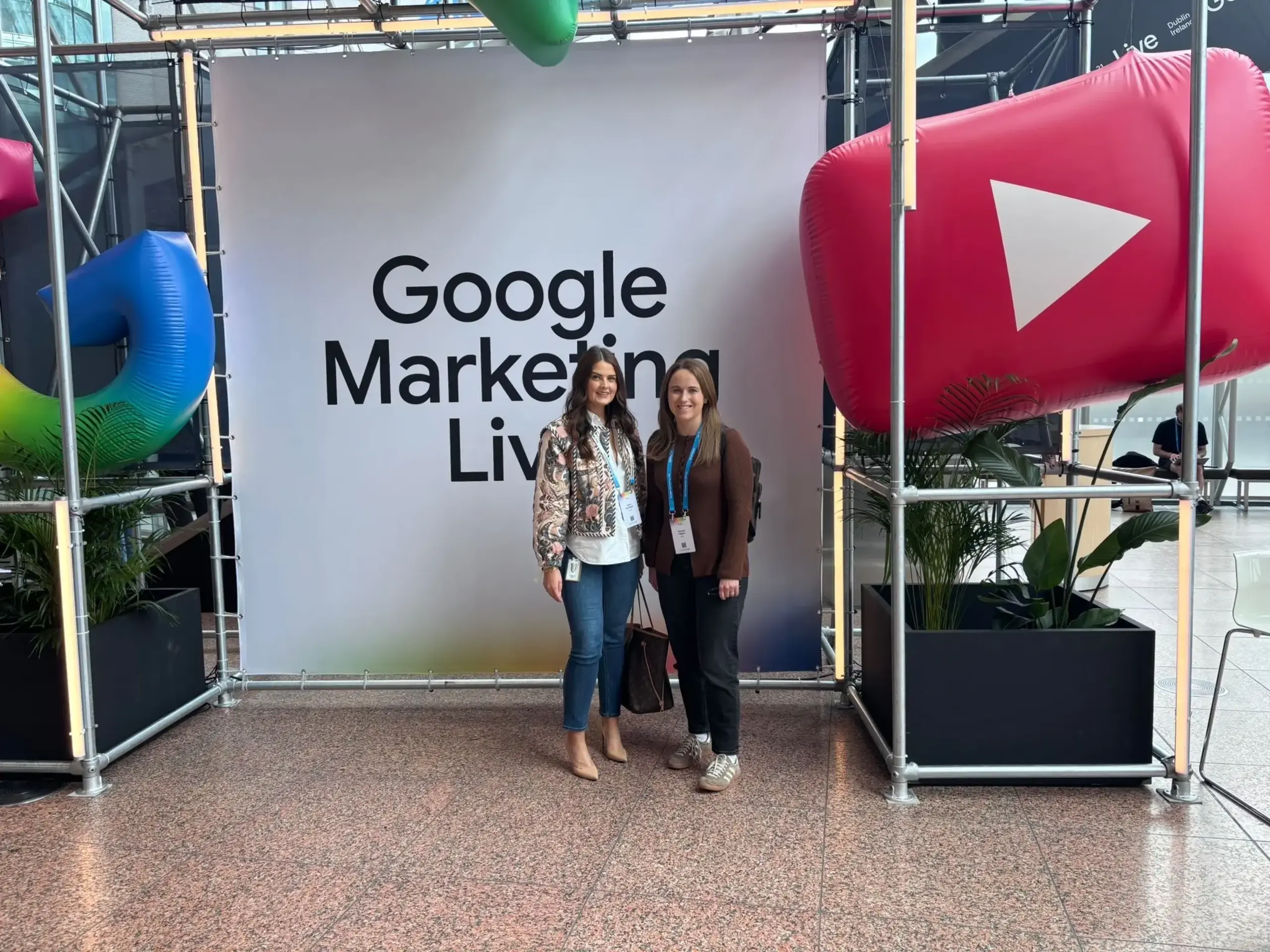 two women standing in front of a sign
